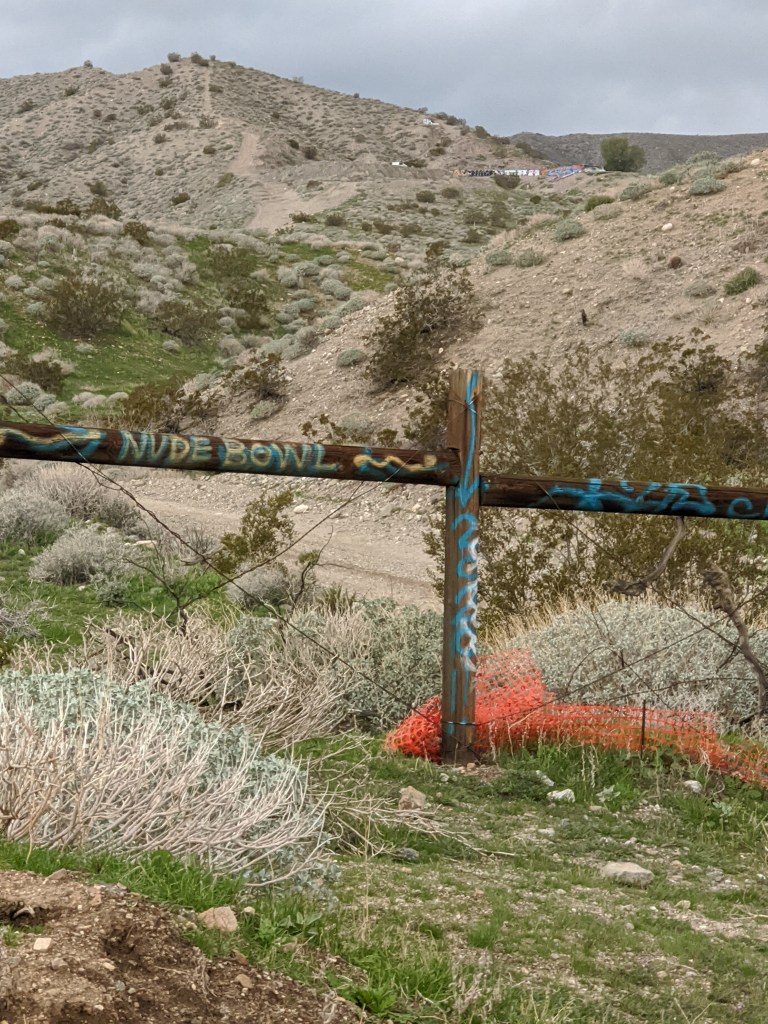 wooden fence painted with "Nude Bowl"