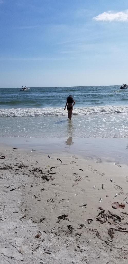 Lydia in Gulf of Mexico with dead fish on shore