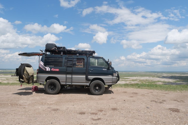 van with blue skies and grasslands
